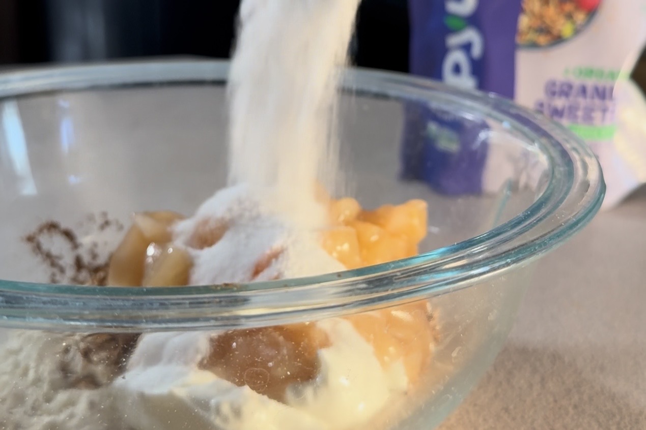 Carbquik being added to apple filling and yogurt in a mixing bowl